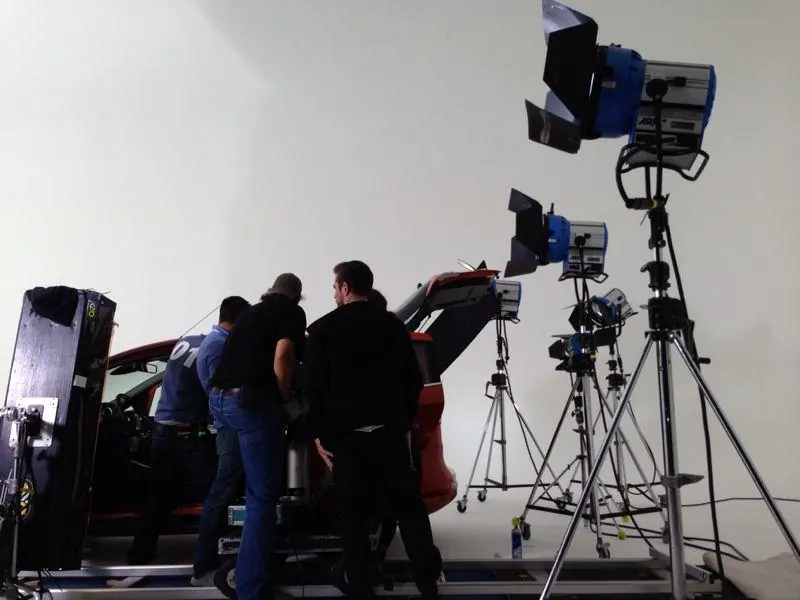 Crew am roten Auto im Studio