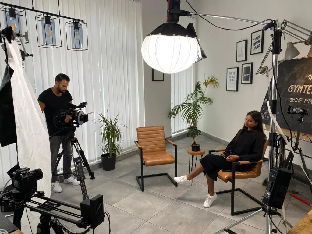 Studio-Set mit Kamera, Licht und Frau im Stuhl